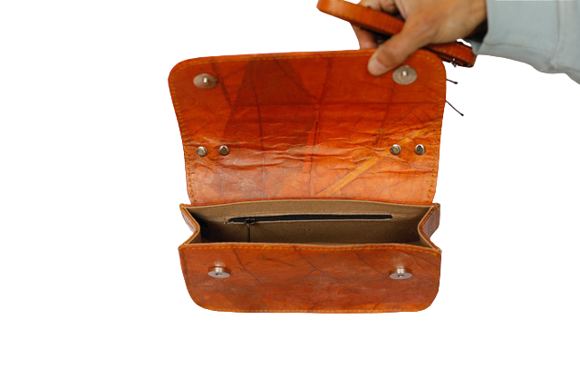 Orange Vegan clutch bag held open by a hand